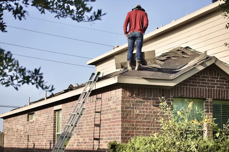 Professional roofer working on a residential roof in Brenham